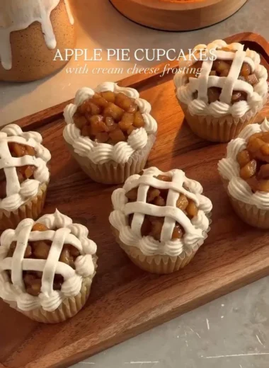 Delicious apple pie cupcakes topped with creamy frosting and apple slices.