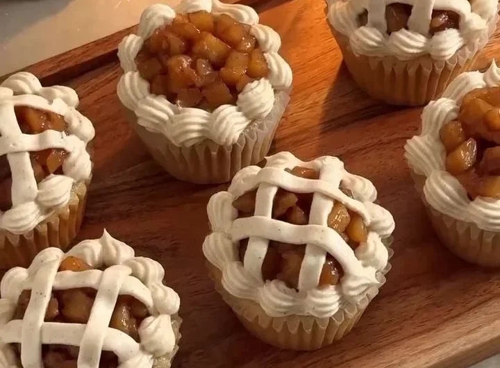 Delicious apple pie cupcakes topped with creamy frosting and apple slices.