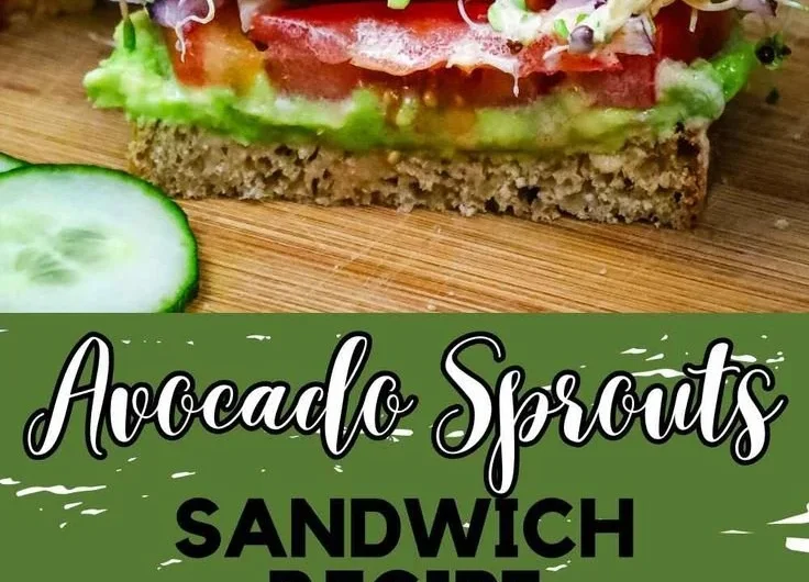 Avocado sprouts sandwich with fresh ingredients on a wooden table.