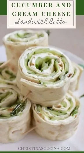 Cucumber and cream cheese sandwich rolls displayed on a platter