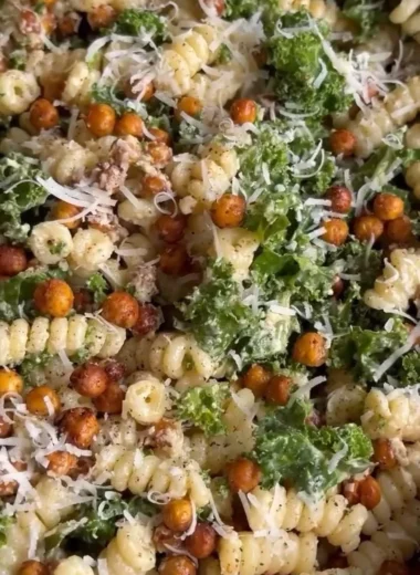 Kale Caesar Pasta Salad with croutons and dressing in a bowl