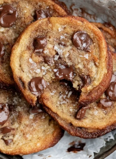 Freshly baked banana bread cookies on a cooling rack, with chocolate chips.