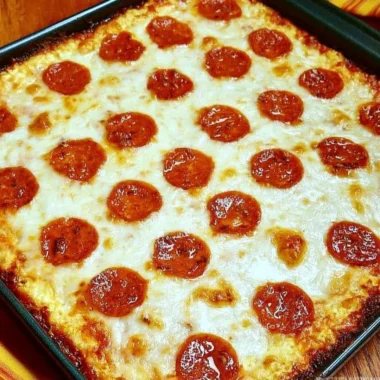 Keto Pizza Casserole topped with cheese and pepperoni in a baking dish