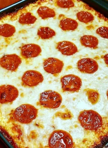 Keto Pizza Casserole topped with cheese and pepperoni in a baking dish