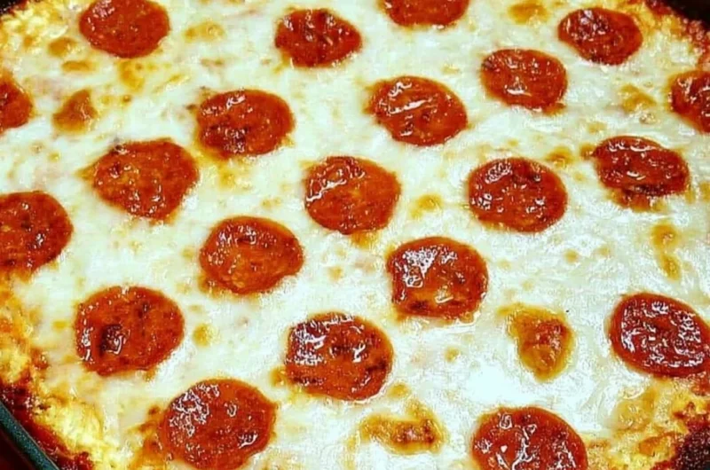 Keto Pizza Casserole topped with cheese and pepperoni in a baking dish