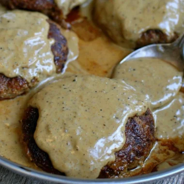 Homemade hamburger steak served with rich gravy on a plate