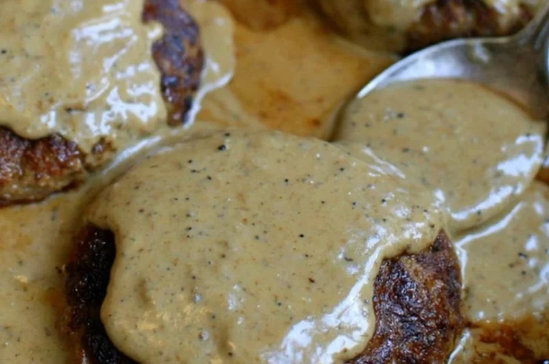 Homemade hamburger steak served with rich gravy on a plate