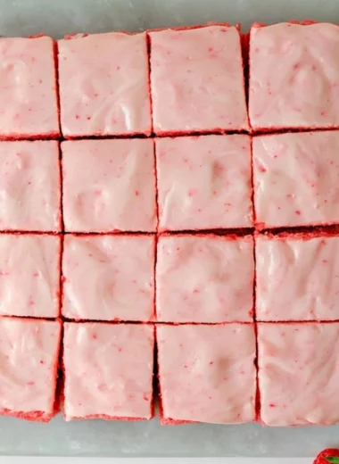 Delicious strawberry brownies with creamy frosting on a white plate