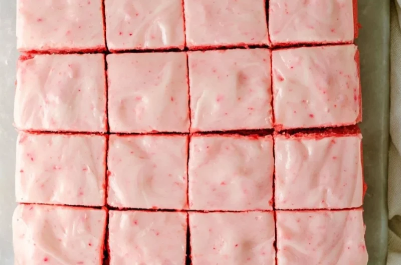 Delicious strawberry brownies with creamy frosting on a white plate