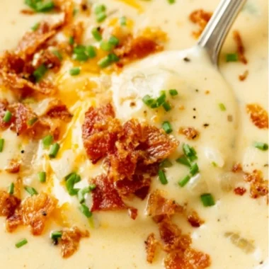 Bowl of creamy baked potato soup topped with cheese and chives