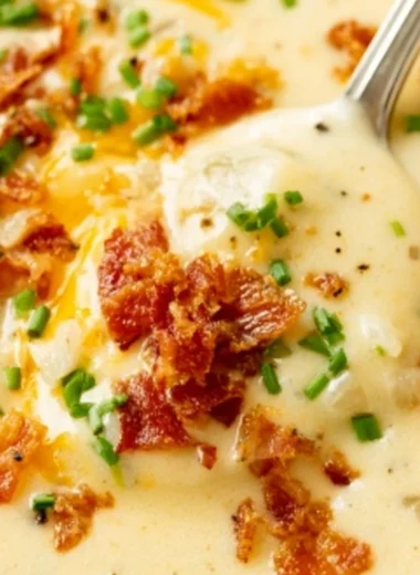 Bowl of creamy baked potato soup topped with cheese and chives