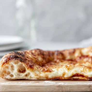 Homemade artisan pizza dough ready for baking with fresh ingredients.