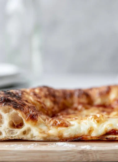 Homemade artisan pizza dough ready for baking with fresh ingredients.