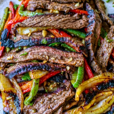Delicious steak fajitas served with colorful peppers and onions