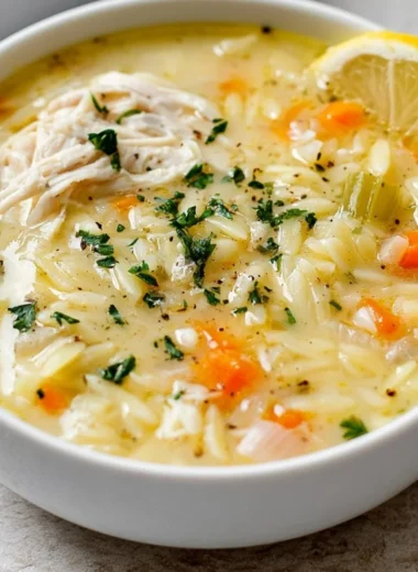 Bowl of easy lemon chicken orzo soup garnished with fresh herbs