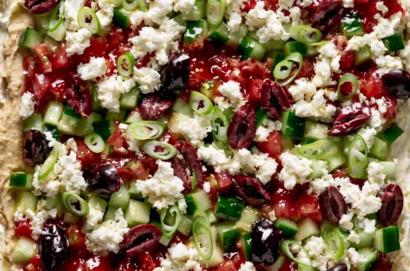 Greek-inspired layered dip with fresh ingredients and Mediterranean flavors.