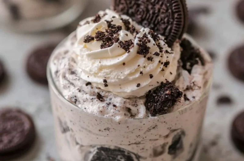 No bake Oreo cheesecake cups topped with crushed Oreos and whipped cream