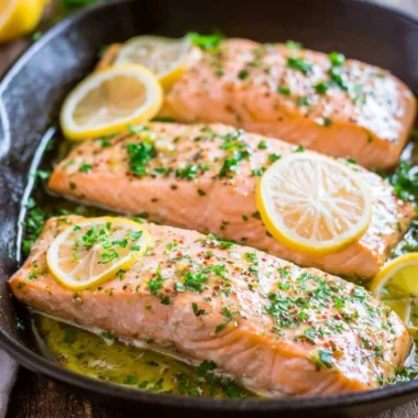 Delicious oven roasted salmon garnished with fresh herbs on a plate.
