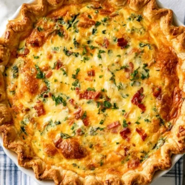 Basic cheesy spinach quiche with turkey bacon served on a plate