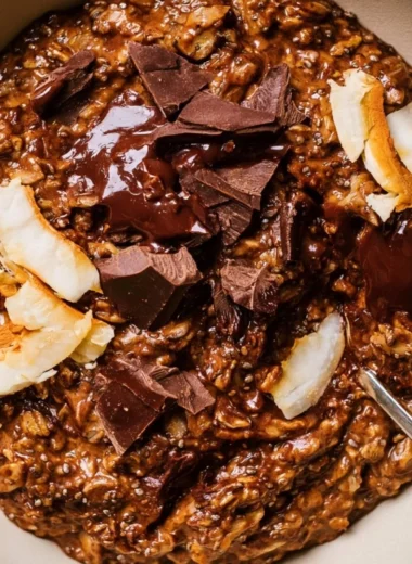 Bowl of chocolate oatmeal topped with fruits and nuts for a delicious breakfast